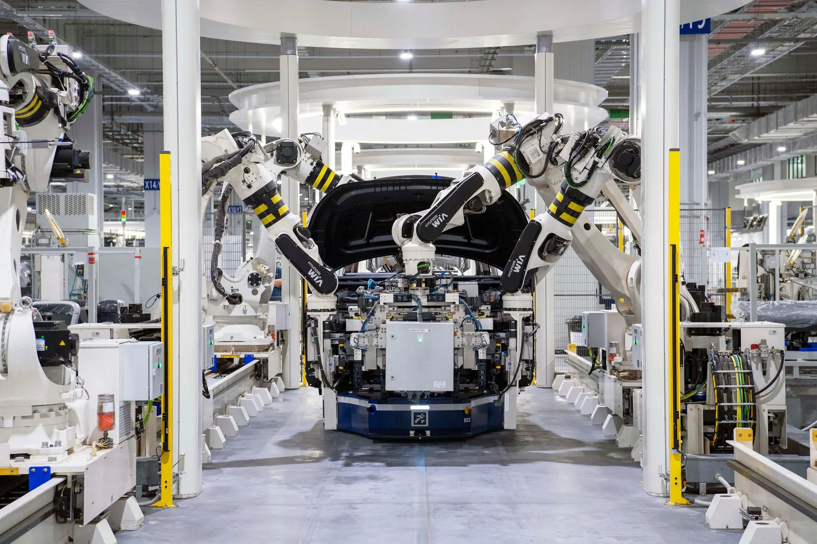 Robotic arms working on a car body on an automotive assembly line