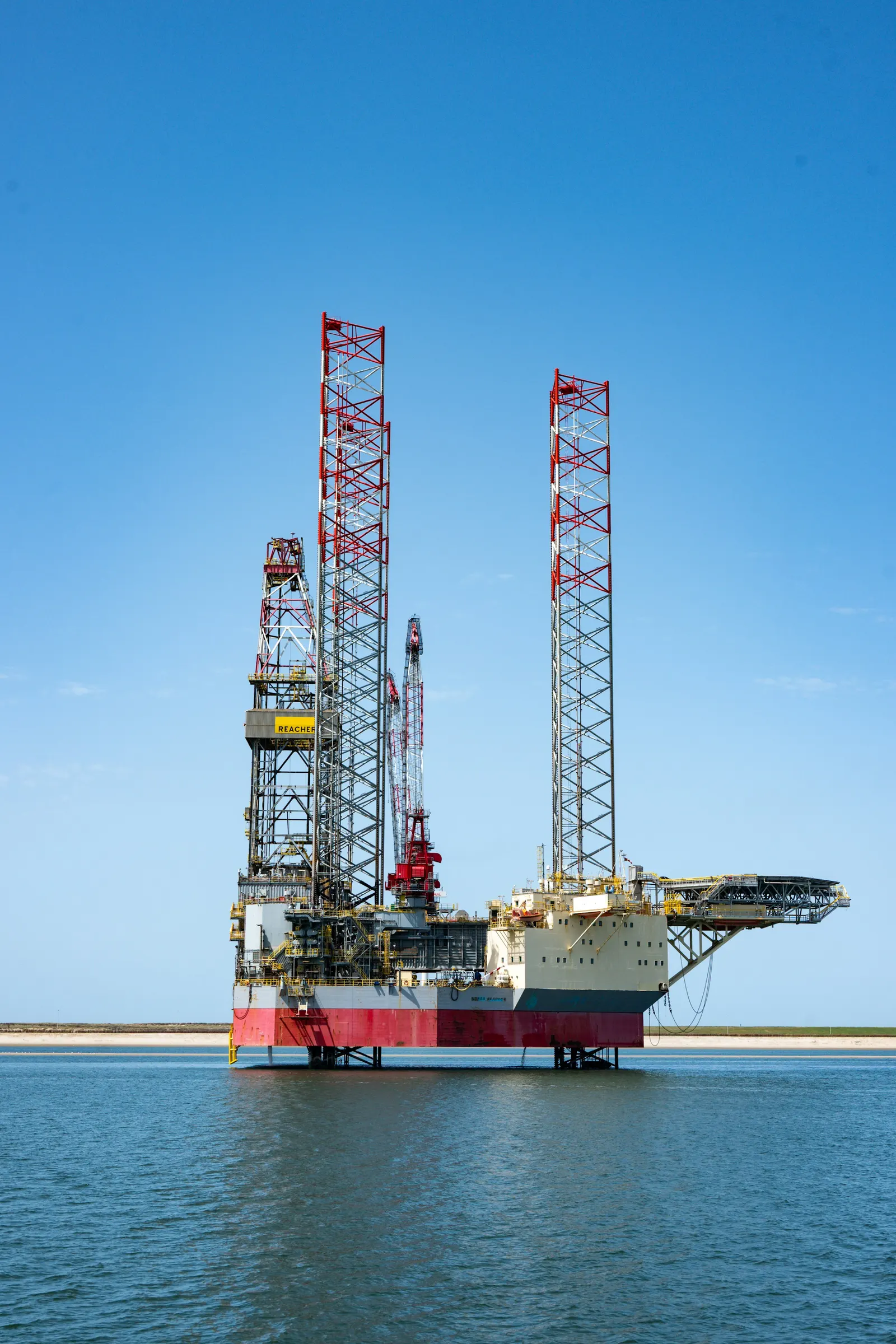 Jack-up rig standing in calm blue water