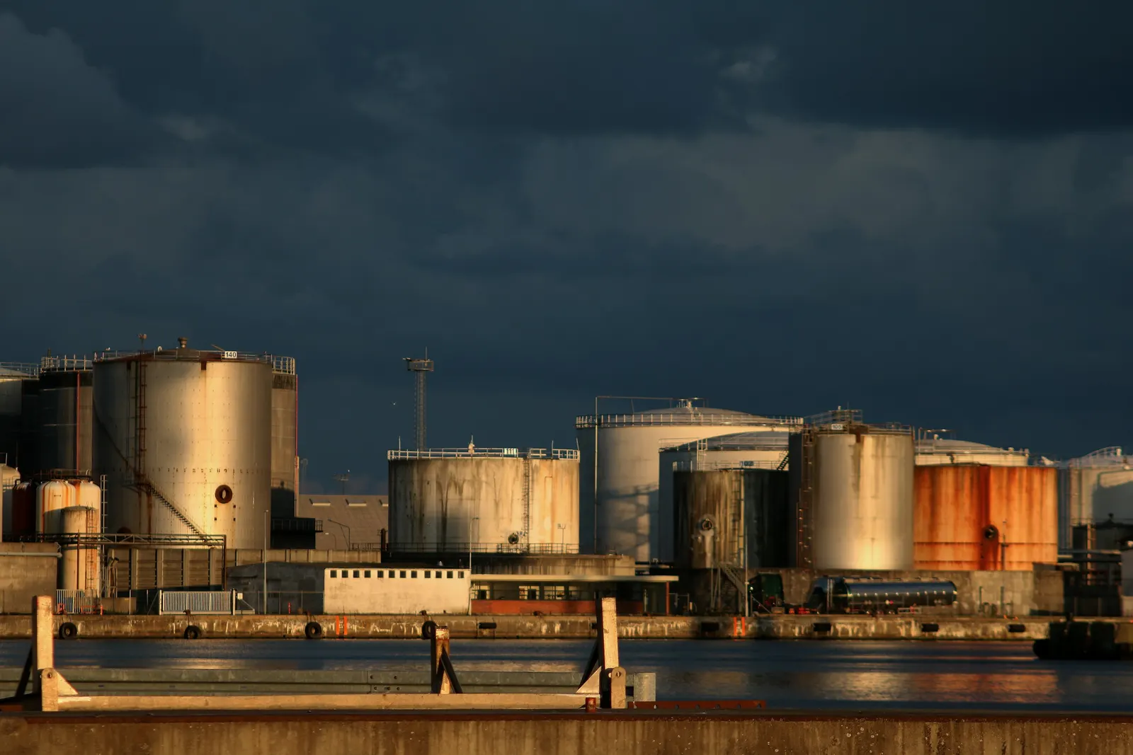 Storage tanks at a petrochemical terminal under a dark sky